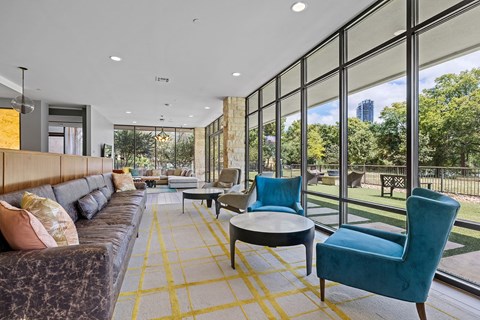 a living room with large windows and a couch and chairs